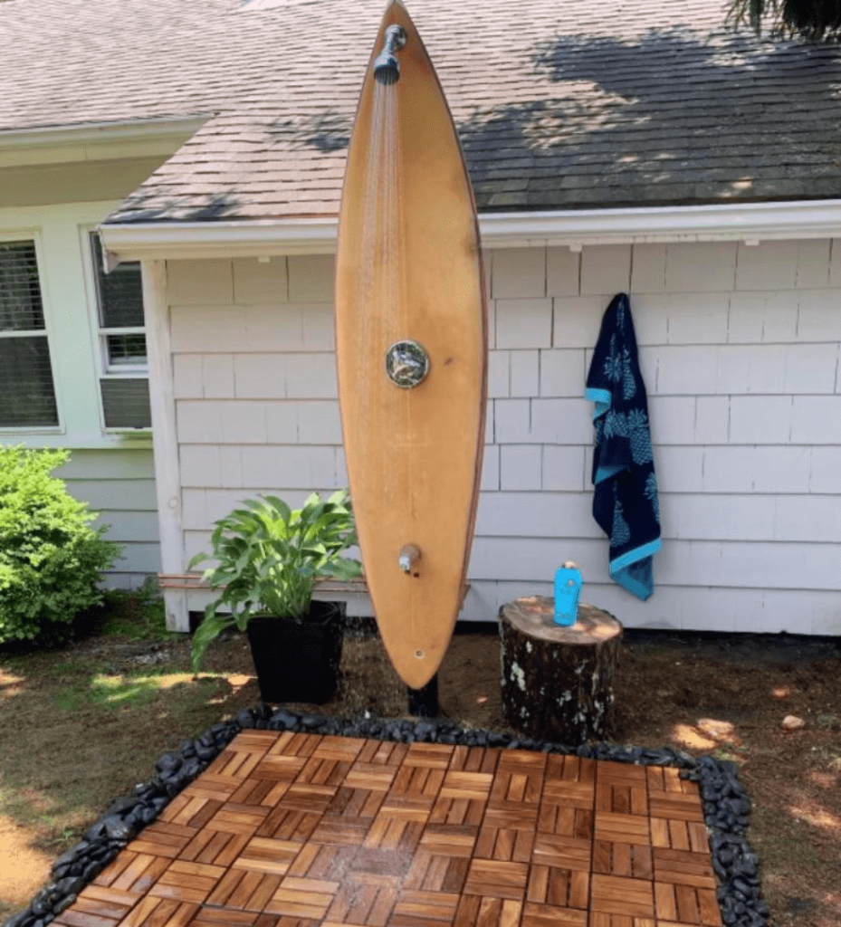Surfboard-shaped outdoor shower setup