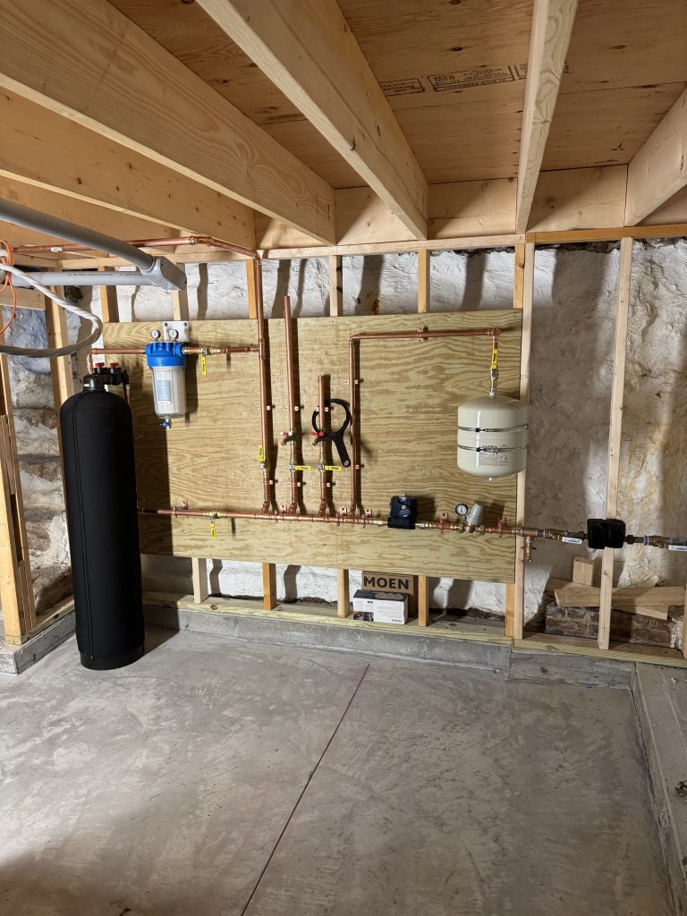 Exposed framing and utilities in a house under construction.