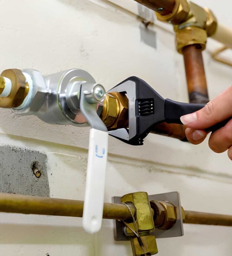 Hand tightening metal pipe with wrench.