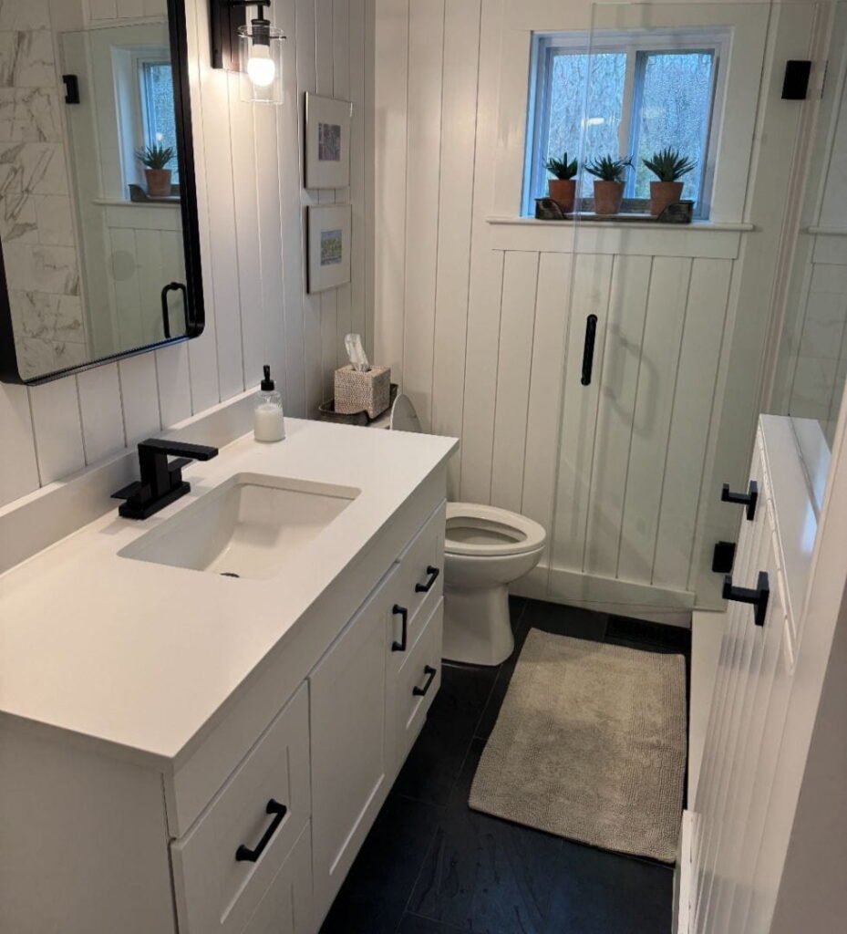 Modern white bathroom with vanity, toilet, and shower in gallery