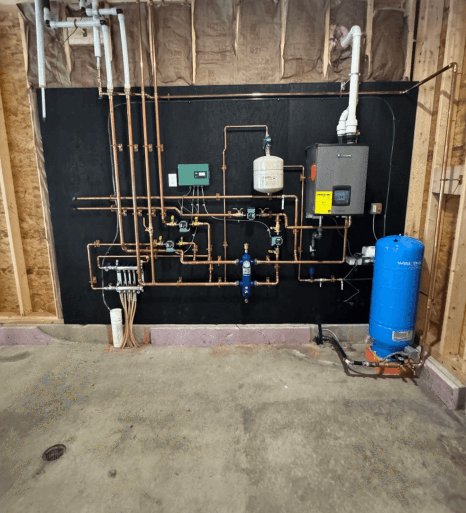 Gallery with copper pipes, valves, and water tank attached to black wall