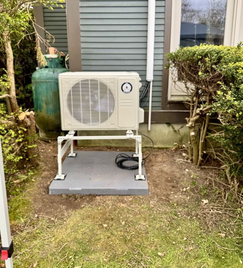 Outdoor AC unit and propane tank next to a house