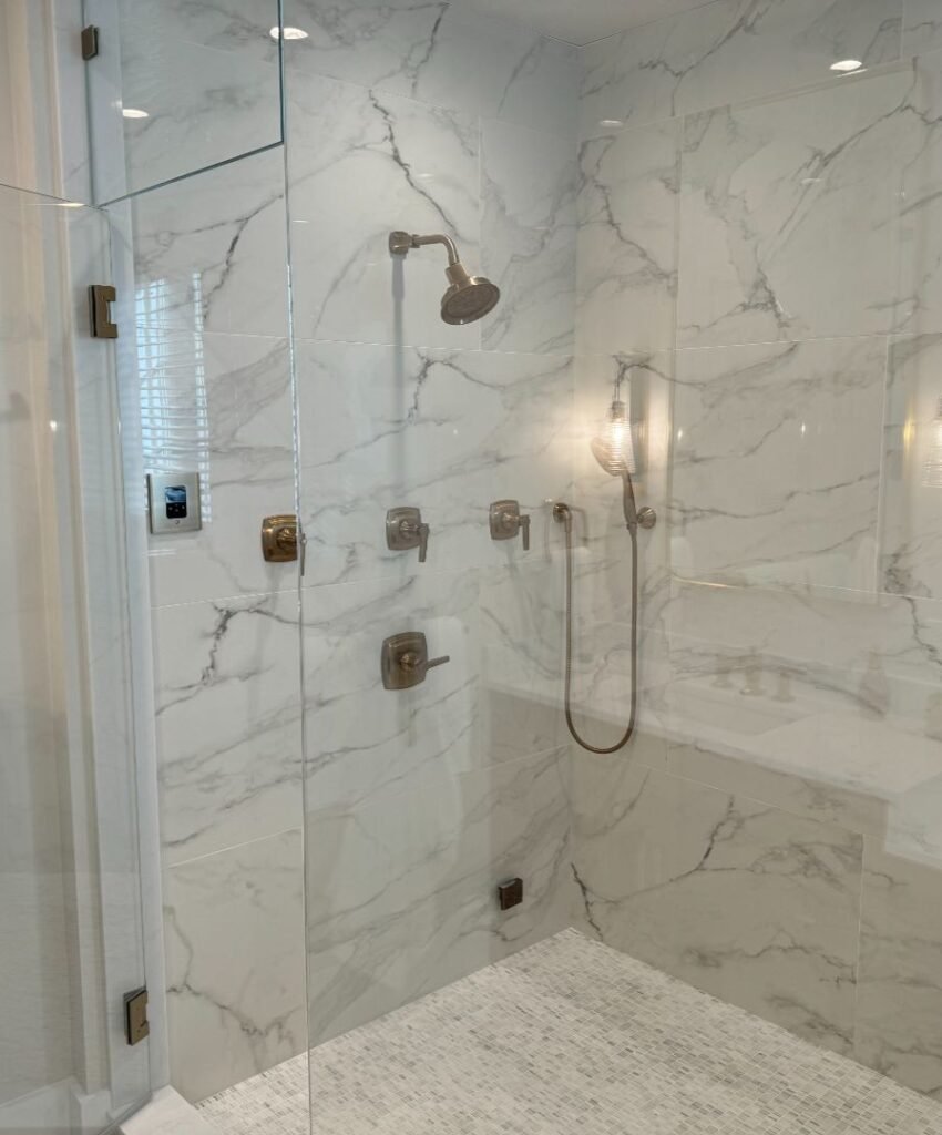 Modern marble shower with glass enclosure
