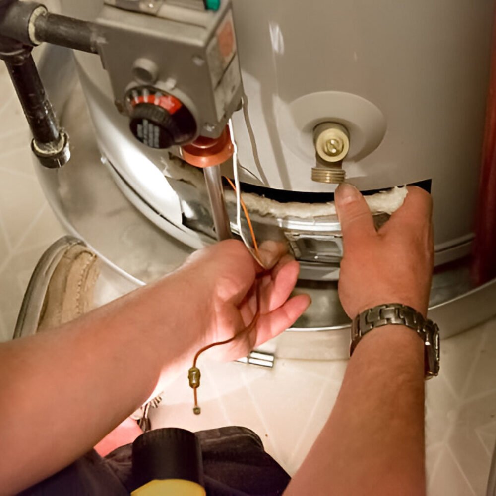 Man shines flashlight on hot water heater