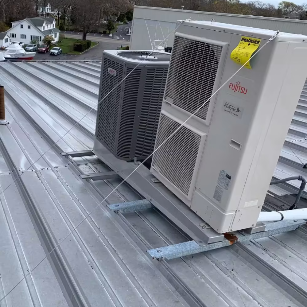 Two outdoor HVAC units on a metal roof, one Fujitsu inverter