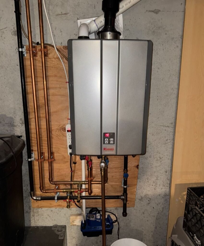 Wall-mounted Rinnai tankless water heater with connected copper and black pipes