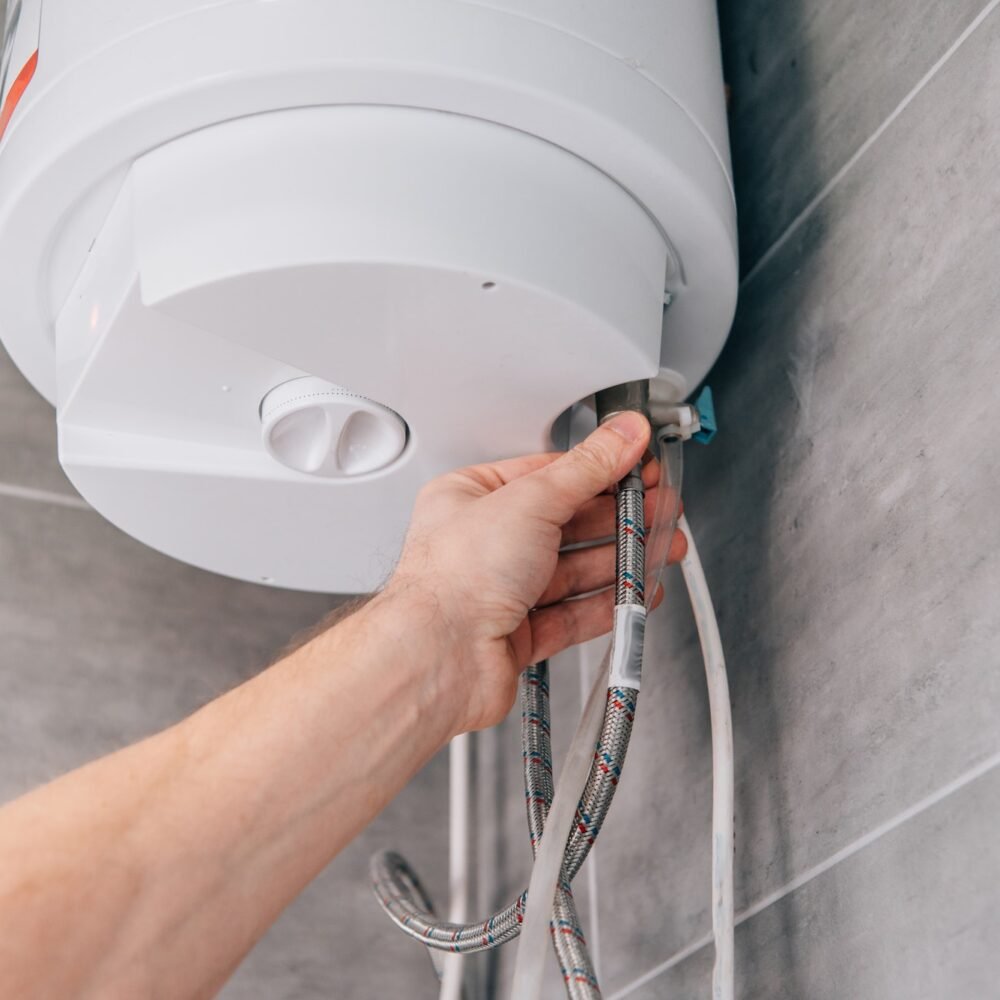 Plumber installing water heater pipe connection